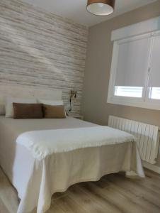 坎加斯德穆拉索CASA LAXE DO BARRO的卧室设有一张白色大床和一扇窗户。