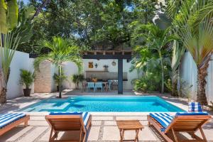 图卢姆Wonderful Tropical Home 3BR, Garden, Private Pool.的后院的游泳池,配有两把椅子和一张桌子