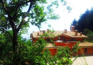 韦莱特里伊尔法尔科农家乐的前面有树木的红房子