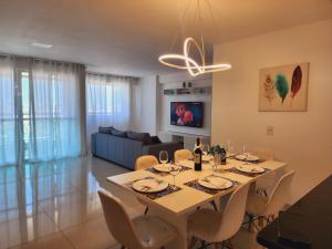 福塔莱萨FORTALEZA APTo INTEIRO 5 HOSPEDES的用餐室以及带桌椅的起居室。