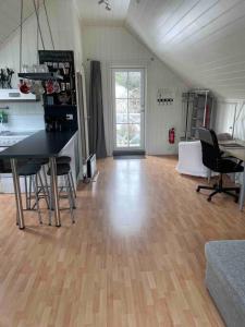HolenKoselig garasjeloft!的客厅铺有木地板,配有桌椅