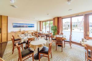 施特拉尔松德Hotel Kontorhaus Stralsund的餐厅设有桌椅和大窗户。