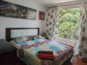 卡利Hospedaje Casa Aurora的一间卧室设有一张床和一个大窗户