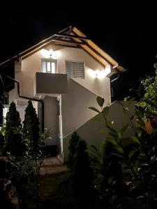 克拉多沃Zanes Guest House的白色房子的一侧有灯