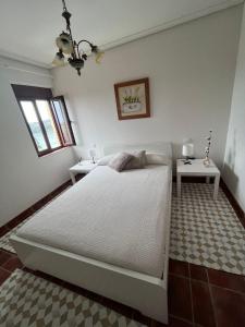 苏安塞斯Casa El Mirador的卧室配有一张白色的大床和两张桌子