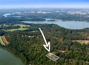 PodjazdyLeśny Dworek Podjazy的享有湖泊的空中景致,设有房屋