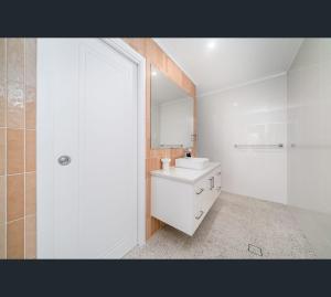 沃加沃加Brand New Luxury Abode on Shaw的白色的浴室设有水槽和镜子
