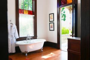 温斯顿·塞勒姆Summit Street Inns的一间带白色浴缸和窗户的浴室