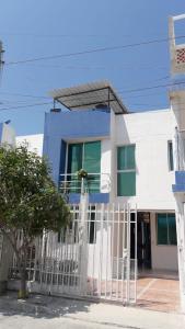 圣玛尔塔Casa Amplia Completa Privada para Familias的白色的蓝色房屋,设有白色的围栏