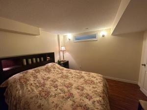 列治文山Basement apartment的一间卧室配有一张带花卉床罩的床