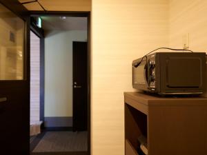京都若平安白川酒店　Waka Heian Shirakawa Hotel的坐在一个房间梳妆台上看电视