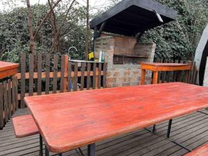 库里科Casa Rural Curicó - Apartamentos的带壁炉的甲板上的木餐桌