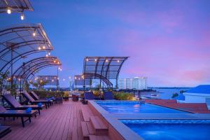 金边欧汉娜金边皇宫酒店的酒店屋顶设有游泳池,享有城市美景。