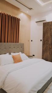 伊凯贾Sapphire Residences by Crystal的卧室配有一张白色大床和木制床头板