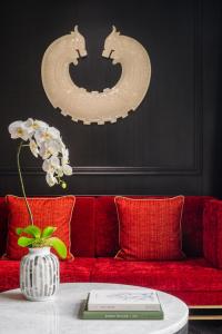 澳门THE KARL LAGERFELD的一张红色的沙发,桌子上放着花瓶