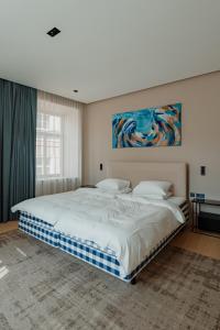 维尔纽斯Royal Marbles的卧室配有一张大床,墙上挂有绘画作品