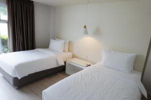 安蒂波洛LeBlanc Hotel的酒店客房设有两张床和窗户。