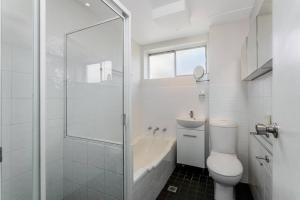 悉尼CRE31 - renovated 1 bedroom unit - Cremorne的白色的浴室设有卫生间和淋浴。