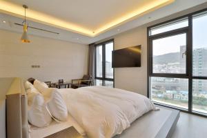 釜山HOTEL YUNA Business的卧室配有一张带白色床单和枕头的大床。