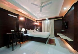 阿格拉Sun - A TAJ VIEW HERITAGE HOTEL的一间卧室设有一张床、一张桌子和天花板