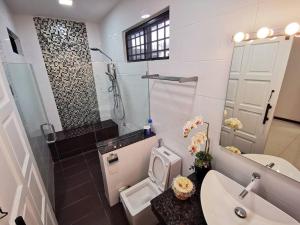 诗巫Family Holiday House @Civic Centre Dewan Suarah的浴室配有卫生间、盥洗盆和淋浴。