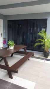 诗巫Family Holiday House @Civic Centre Dewan Suarah的木餐桌,在种植了盆栽植物的房间里