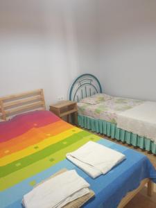 安塔利亚Beldibi Apart Homes的客房设有两张床,配有色彩缤纷的床单和毛巾。