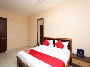 加济阿巴德OYO Flagship Grand Aashirwad的一间卧室配有一张带红色枕头的大床