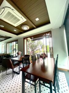 清迈Baannalin Hometel บ้านนลิน โฮมเทล的一间带木桌和椅子的用餐室