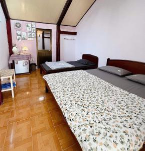 隆海Mai Anh Homestay Long Hải的一间卧室设有两张床,铺有木地板