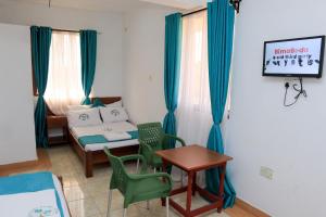 姆特瓦帕Greenyard Resort Mtwapa的小房间设有一张床、一张桌子和椅子