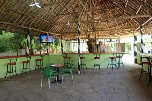 姆特瓦帕Greenyard Resort Mtwapa的酒吧配有桌椅和电视