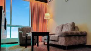 哥打京那巴鲁哥打京那巴鲁婆罗洲酒店&机场酒店的客厅配有沙发、椅子和灯