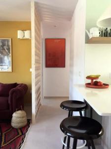 卡达克斯Apartamento renovado en Cadaqués的客厅设有2个酒吧凳和1张沙发
