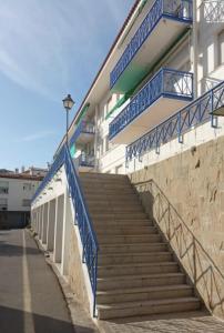 卡达克斯Apartamento renovado en Cadaqués的建筑旁边设有蓝色栏杆的楼梯