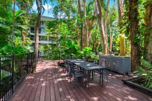 棕榈湾Hotel Drift 3205的木甲板上种有树木,配有桌椅
