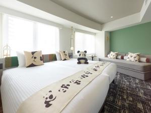 东京Mitsui Garden Hotel Ueno - Tokyo Reopened in July 2023的一间卧室配有两张带熊猫熊的床和一张沙发。