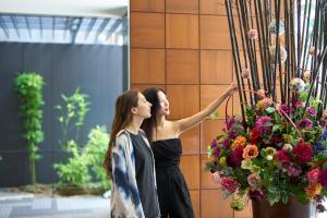 金泽金泽三神大酒店的两个女人站在墙上插花