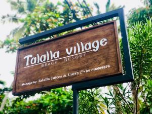 南塔拉拉Talalla Village Beach Resort的塔维拉村海滩度假村的标志