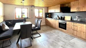 上罗伊特FeWo Apfel-Stadl, Oberreute的厨房配有木制橱柜和桌椅