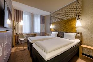 科隆科隆杜姆宜必思酒店的酒店客房设有两张床和一张桌子。