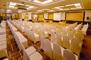 北干巴鲁北干巴鲁加特拉大酒店的大房间设有白色椅子和白色板