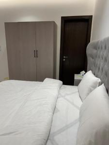 吉达اطلالة الريان شقة خاصة的卧室内的一张带白色床单和枕头的床