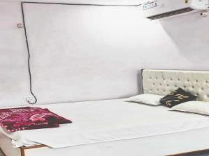 KhagaulOYO Flagship 83165 Hotel Om Shanti的一张带床头板和枕头的白色床