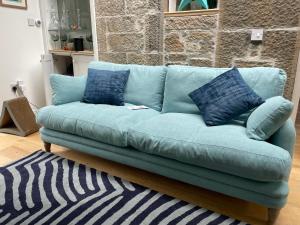 爱丁堡Large 3 double bedroom period house with parking的客厅配有蓝色沙发及蓝色枕头