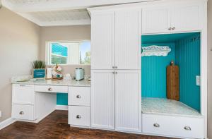圣徒皮特海滩Hummingbird Hideaway的厨房配有白色橱柜和蓝色的墙壁