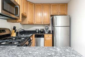 芝加哥Gold Coast 1BR nr Mariano Park Oak St Beach CHI-259的厨房配有木制橱柜和不锈钢冰箱。