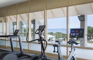 图彻皮Bluesun Holiday Village Afrodita的健身房设有2台有氧运动器材和大窗户