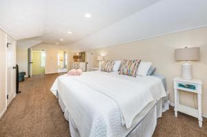 圣徒皮特海滩Hummingbird Hideaway的一间卧室配有一张白色大床和床头柜