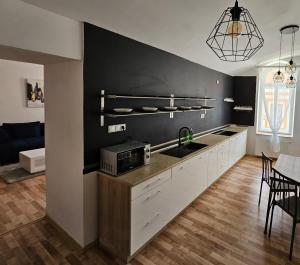 普雷绍夫Penzión TIME的厨房配有白色橱柜和黑色墙壁
